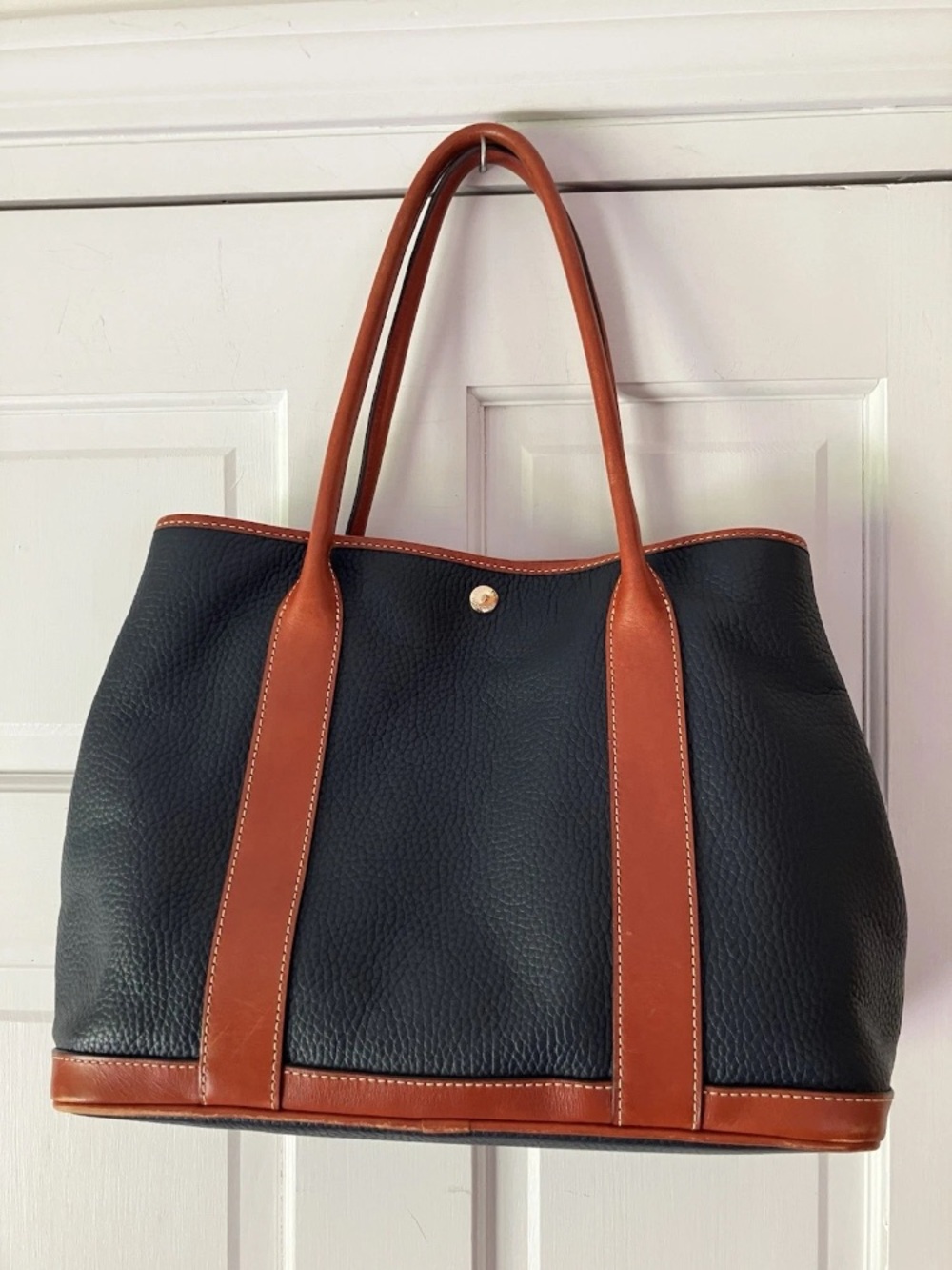 Dooney & Bourke Pebbled Leather Black Tote with Brown Trim and Handles.